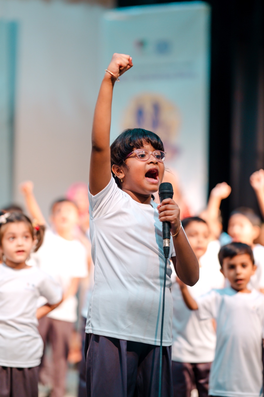 Child raising her fist while speaking at a Kochi Konther Asar event